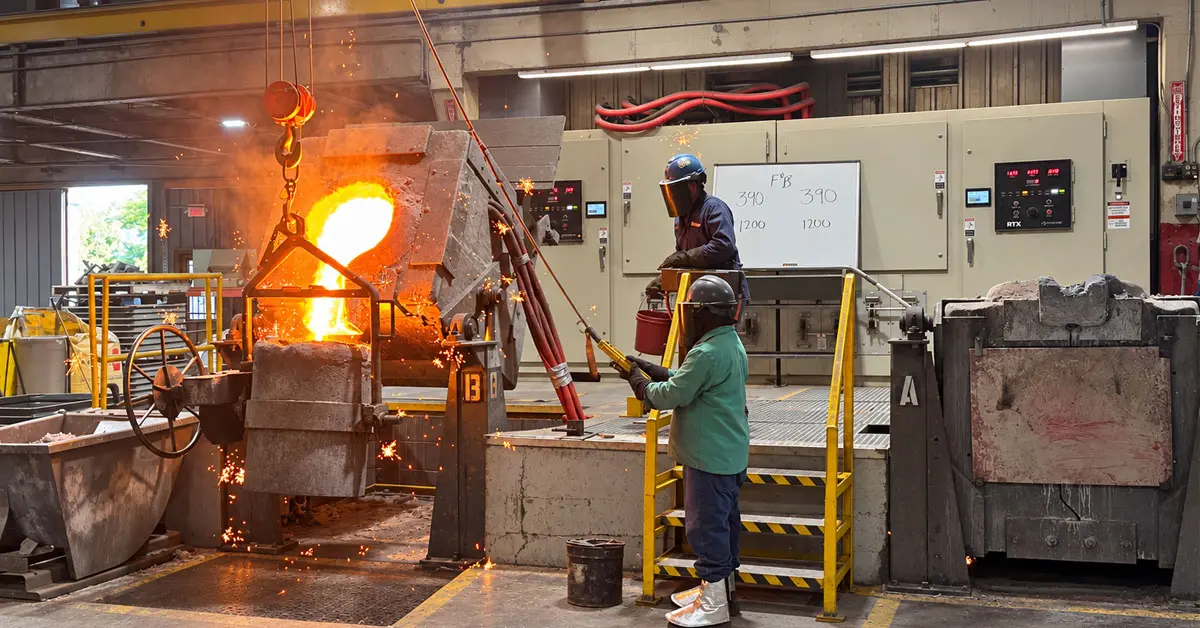 Foundry induction furnace pouring molten iron in front of new electric panels